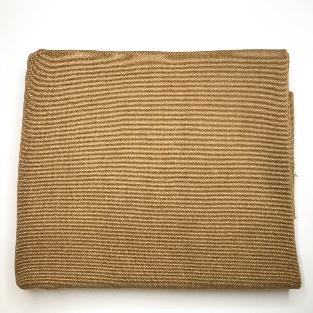 Folded piece of heavy weight bubble linen fabric in warm peanut brown color, showing texture and weave on a white background.