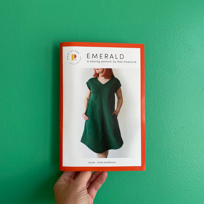 Made By Rae Emerald Dress pattern featuring a V-shaped neckline, curved hem, and optional pockets