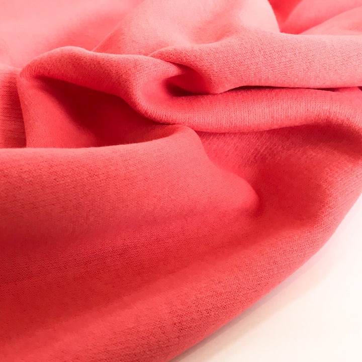 Coral Sweatshirt Brushed Fleece fabric with soft brushed texture and fluffy back, ideal for cozy apparel

