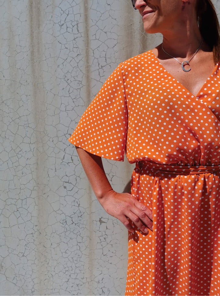 Style Arc Bonita Dress sewing pattern with wrap front, fluted sleeves, and tie belt design