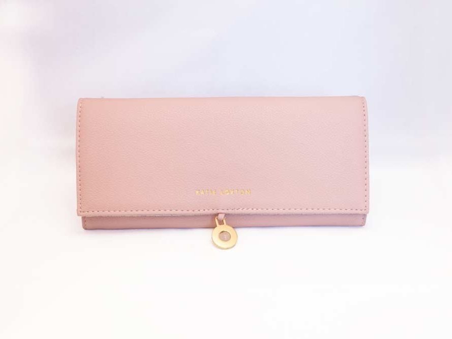 Travel Jewelry Organizer Roll in soft pink and navy faux-leather with compartments for rings, necklaces, and earrings.