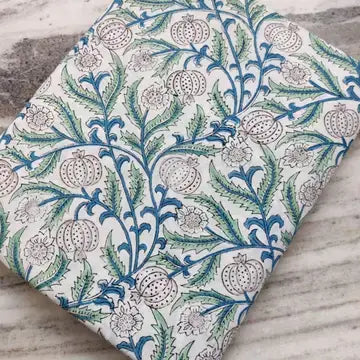 White botanical printed cotton fabric with blue green vines and vegetable blooms