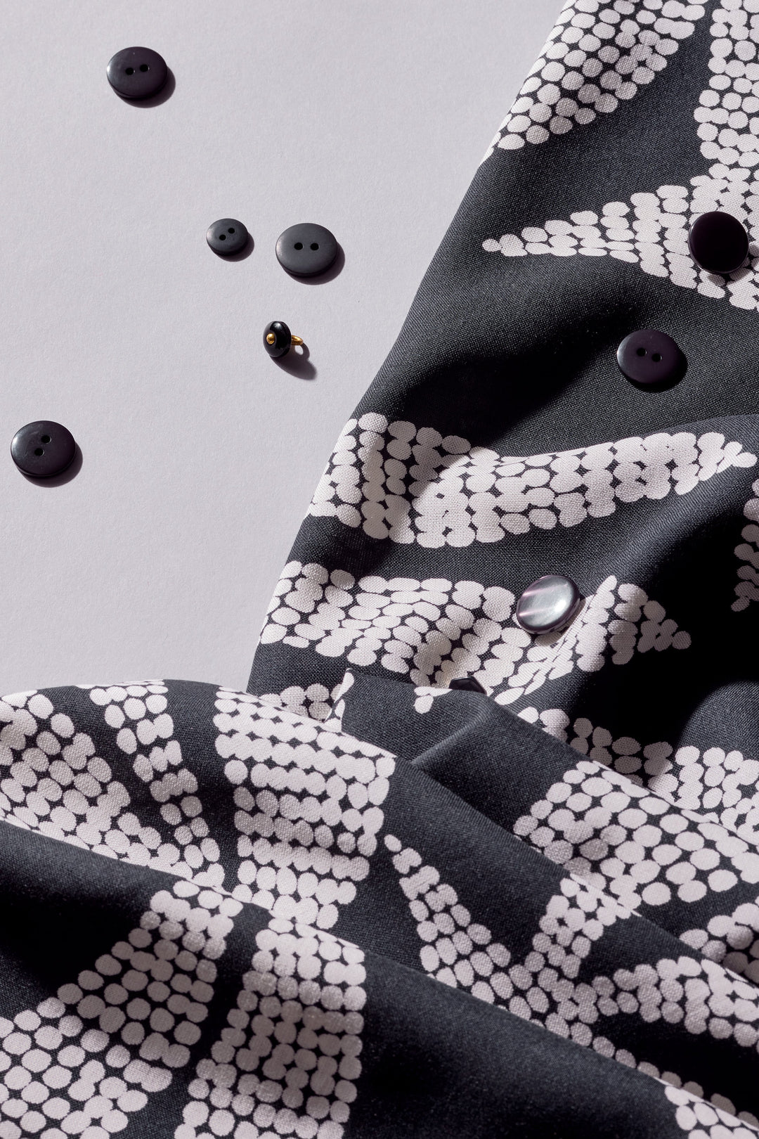 Viscose Challis fabric in deep charcoal with white leaf print, lightweight 55-inch wide textile for dresses, skirts, and blouses