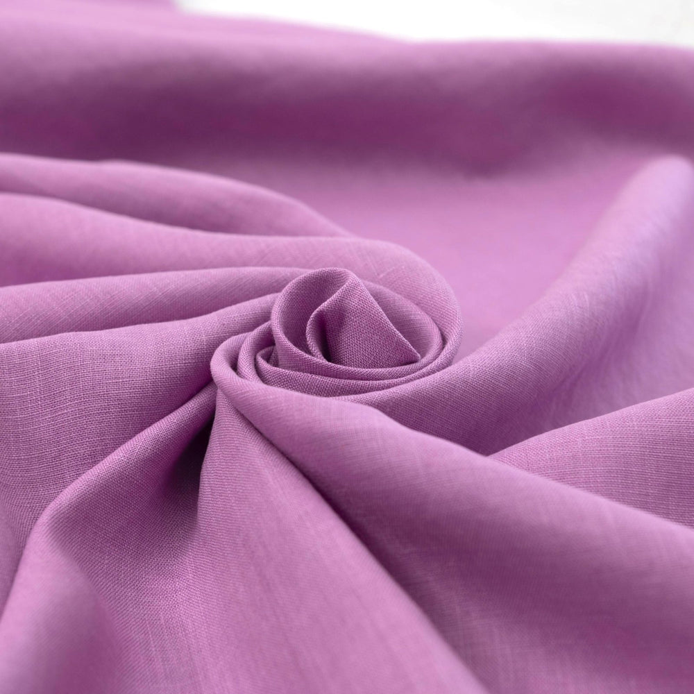 Fresh lilac linen fabric with soft drape, breathable lightweight texture, ideal for sewing dresses, skirts, blouses, and summer apparel.

