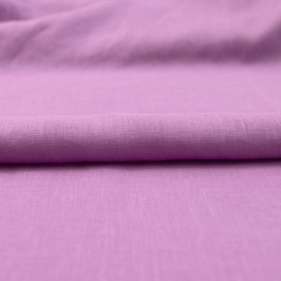 Fresh lilac linen fabric with soft drape, breathable lightweight texture, ideal for sewing dresses, skirts, blouses, and summer apparel.

