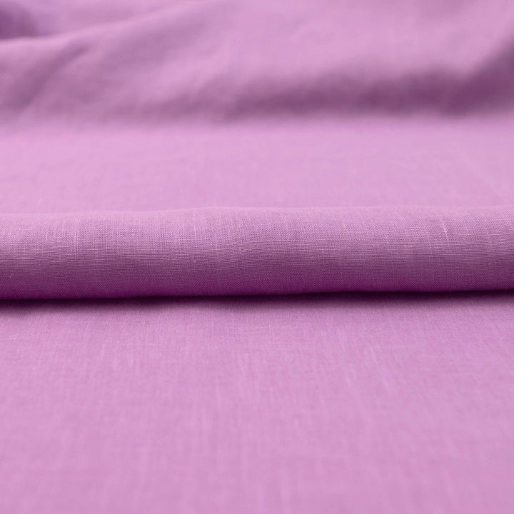 Fresh lilac linen fabric with soft drape, breathable lightweight texture, ideal for sewing dresses, skirts, blouses, and summer apparel.

