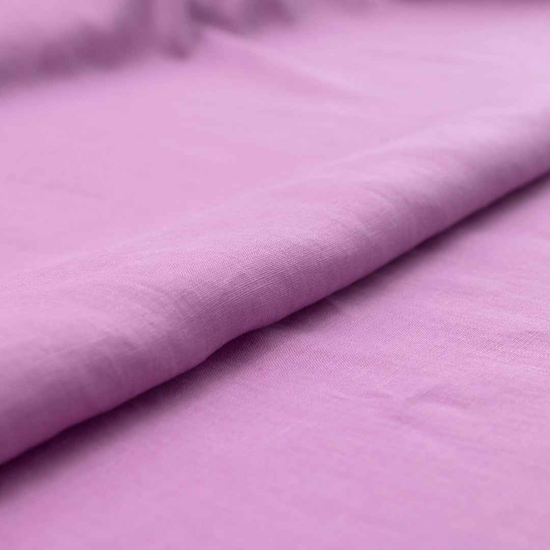 Fresh lilac linen fabric with soft drape, breathable lightweight texture, ideal for sewing dresses, skirts, blouses, and summer apparel.

