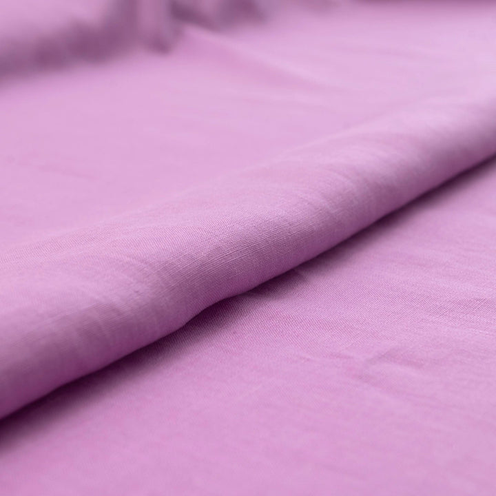 Fresh lilac linen fabric with soft drape, breathable lightweight texture, ideal for sewing dresses, skirts, blouses, and summer apparel.

