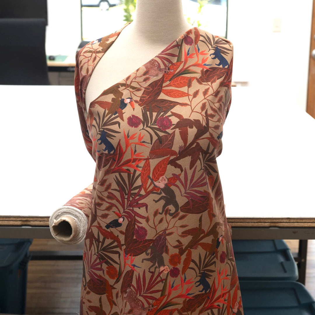 Italian linen fabric in brown with jungle print – features monkeys, birds, and deer on soft yet crisp lightweight linen, ideal for shirts, dresses, and skirts