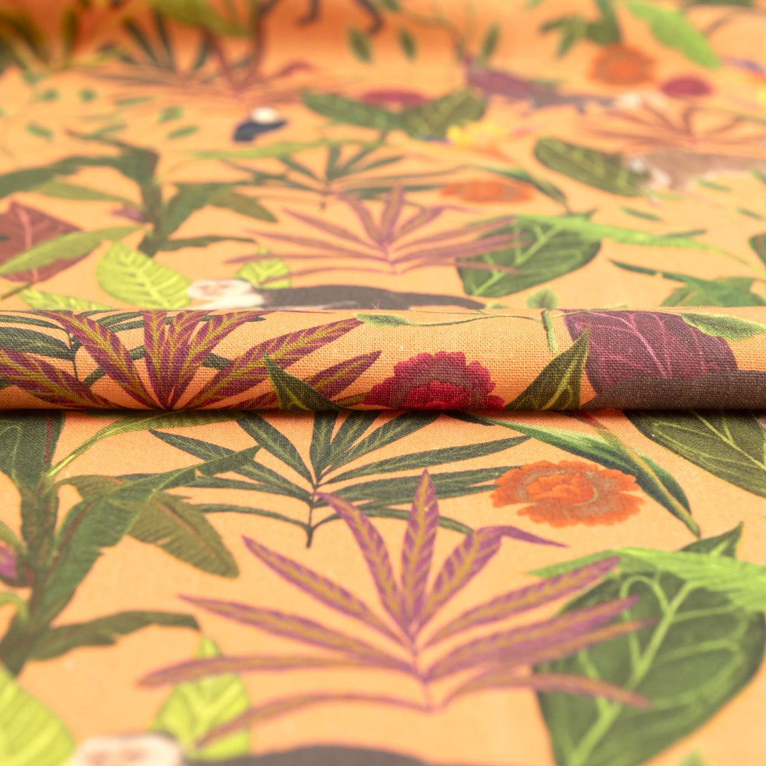 "Italian linen fabric in vibrant orange with jungle print – features monkeys, birds, and deer on lightweight linen, perfect for shirts, dresses, and skirts"

