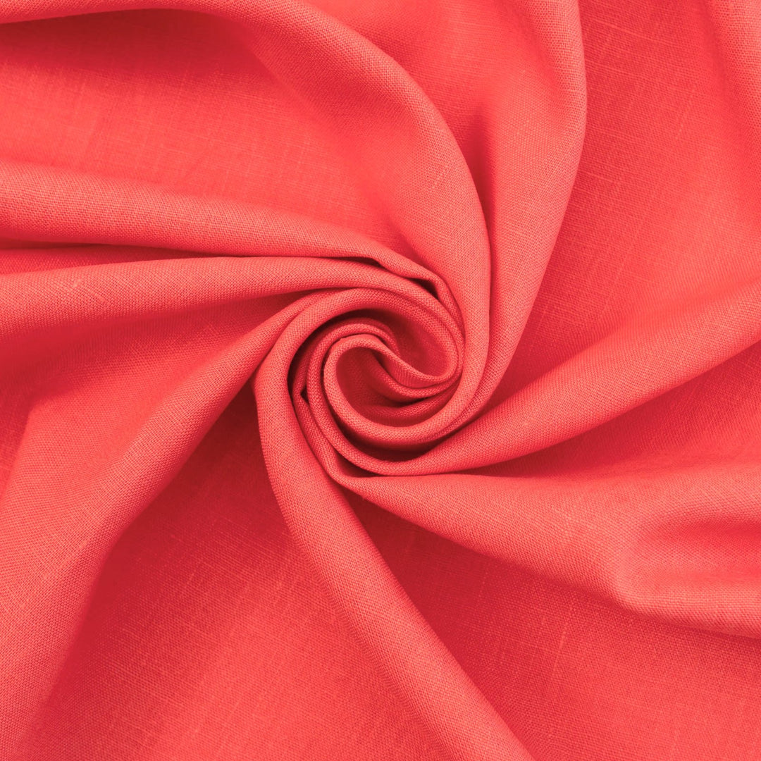 Bright living coral linen fabric with soft drape, breathable lightweight texture, ideal for sewing dresses, skirts, blouses, and summer clothing.


