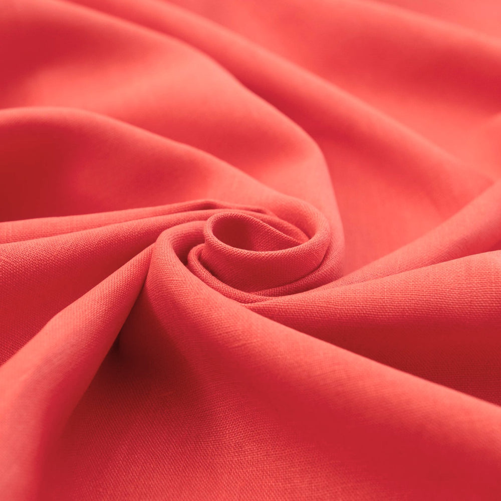 Bright living coral linen fabric with soft drape, breathable lightweight texture, ideal for sewing dresses, skirts, blouses, and summer clothing.

