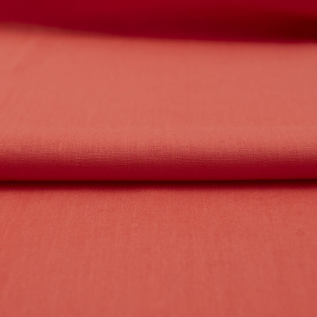 Bright living coral linen fabric with soft drape, breathable lightweight texture, ideal for sewing dresses, skirts, blouses, and summer clothing.

