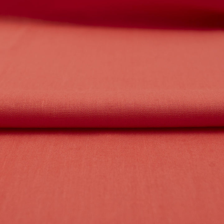 Bright living coral linen fabric with soft drape, breathable lightweight texture, ideal for sewing dresses, skirts, blouses, and summer clothing.

