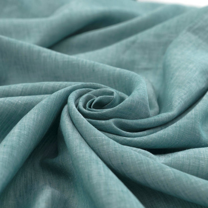 Teal linen chambray fabric, lightweight and breathable, with a soft texture ideal for sewing dresses, tunics, blouses, and year-round apparel.

