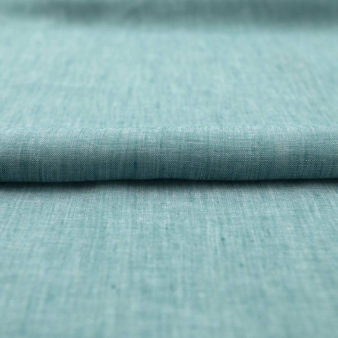 Teal linen chambray fabric, lightweight and breathable, with a soft texture ideal for sewing dresses, tunics, blouses, and year-round apparel.

