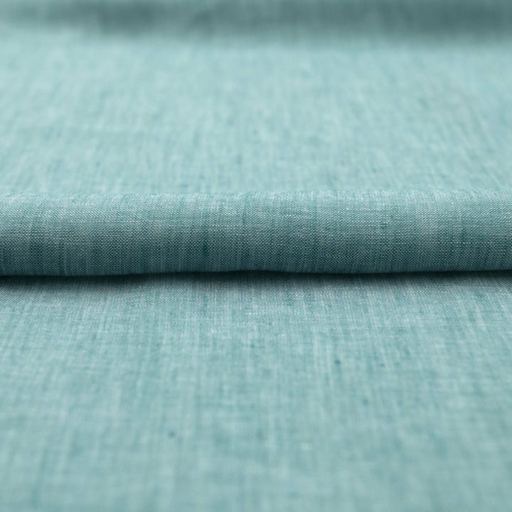 Teal linen chambray fabric, lightweight and breathable, with a soft texture ideal for sewing dresses, tunics, blouses, and year-round apparel.

