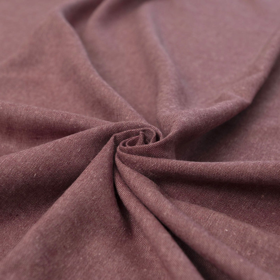 Close-up of Linen/Rayon Yarn Dye fabric in plum color showing textured yarn-dyed pattern and rich color variation.

