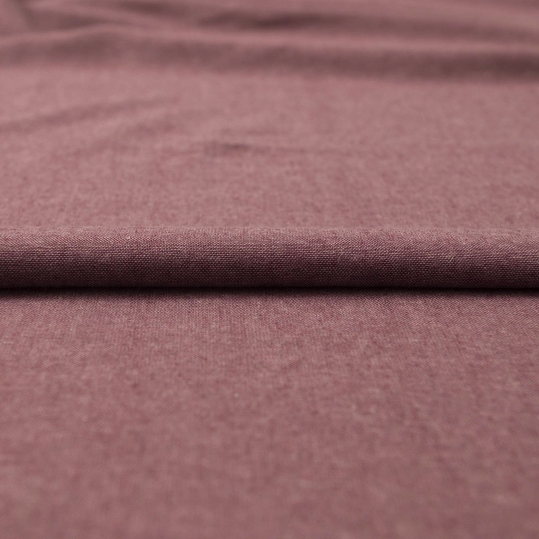 Close-up of Linen/Rayon Yarn Dye fabric in plum color showing textured yarn-dyed pattern and rich color variation.

