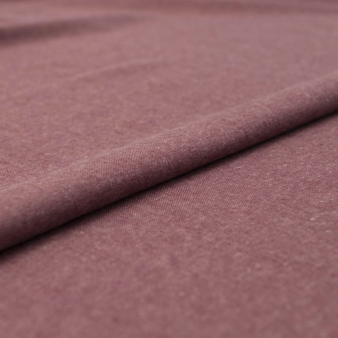 Close-up of Linen/Rayon Yarn Dye fabric in plum color showing textured yarn-dyed pattern and rich color variation.

