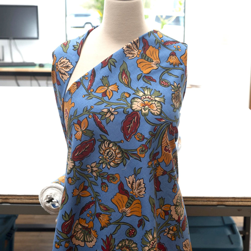 Linen and cotton blend fabric – Bloomscape on cornflower blue by Zara, Italian deadstock with vibrant marigold, wine, and green floral print