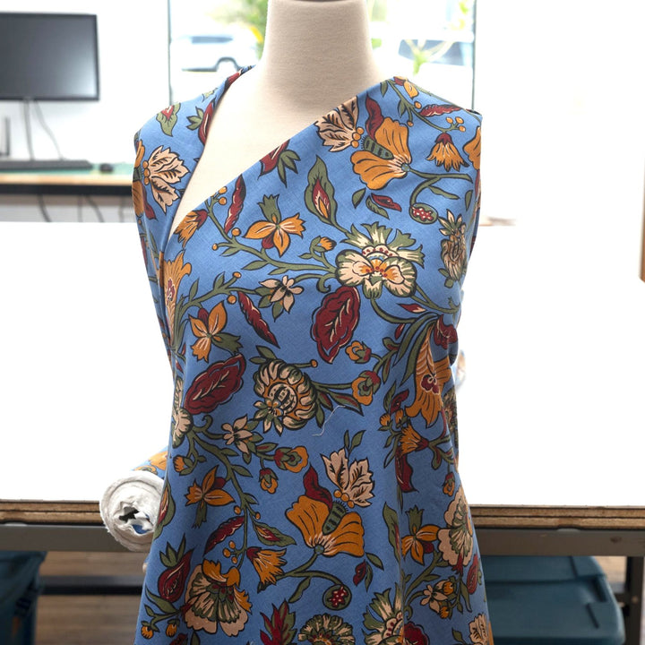 Linen and cotton blend fabric – Bloomscape on cornflower blue by Zara, Italian deadstock with vibrant marigold, wine, and green floral print