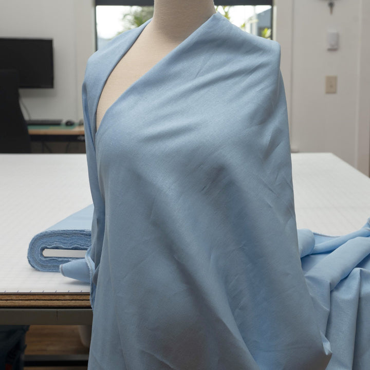 Pale blue linen and cotton blend fabric, mid-weight, soft, breathable, and opaque, perfect for sewing dresses, shirts, pants, and lightweight jackets.

