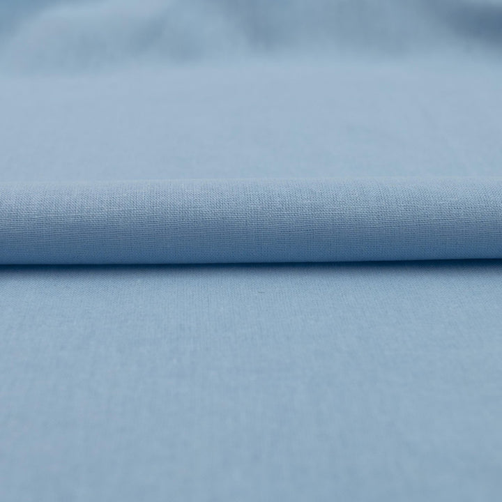 Pale blue linen and cotton blend fabric, mid-weight, soft, breathable, and opaque, perfect for sewing dresses, shirts, pants, and lightweight jackets.

