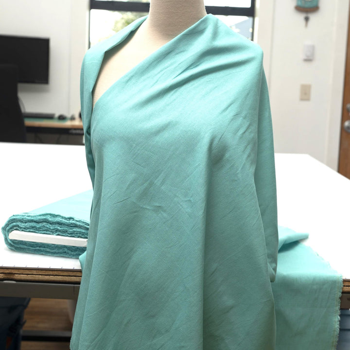 Pale jade linen and cotton blend fabric, mid-weight, soft, breathable, and opaque, ideal for sewing dresses, shirts, pants, and lightweight jackets.