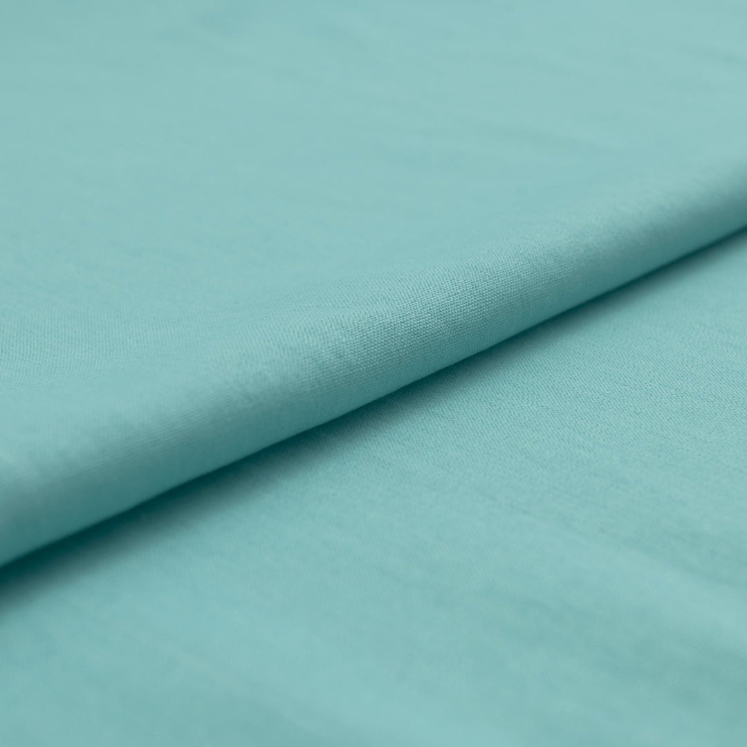 Pale jade linen and cotton blend fabric, mid-weight, soft, breathable, and opaque, ideal for sewing dresses, shirts, pants, and lightweight jackets.