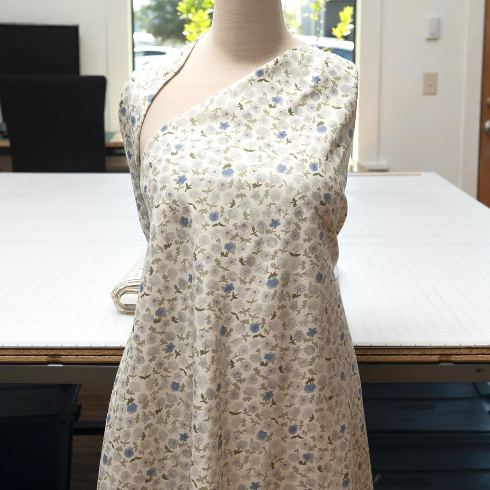 Linen and cotton blend fabric with soft blue floral pattern and green stems, 56-inch wide lightweight fabric