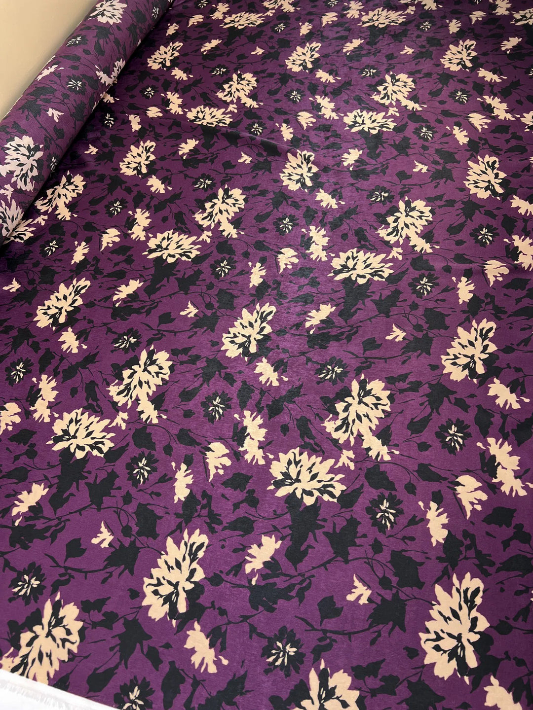 Italian dressweight sateen fabric with purple, black, and beige leaf pattern, lightweight polyester textile ideal for structured dresses, skirts, and suiting.