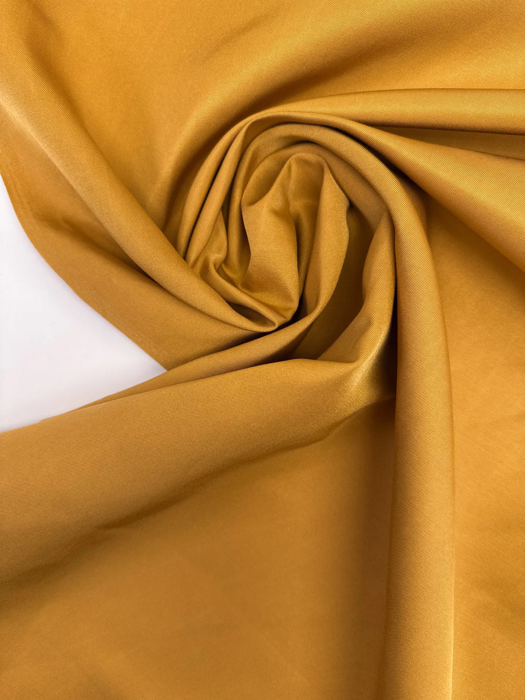Premium Silk Twill fabric in mustard yellow color. Made from 100% pure silk. Ideal for unstructured dresses, skirts, and blouses.