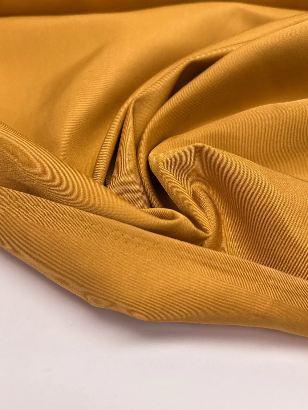 Premium Silk Twill fabric in mustard yellow color. Made from 100% pure silk. Ideal for unstructured dresses, skirts, and blouses.