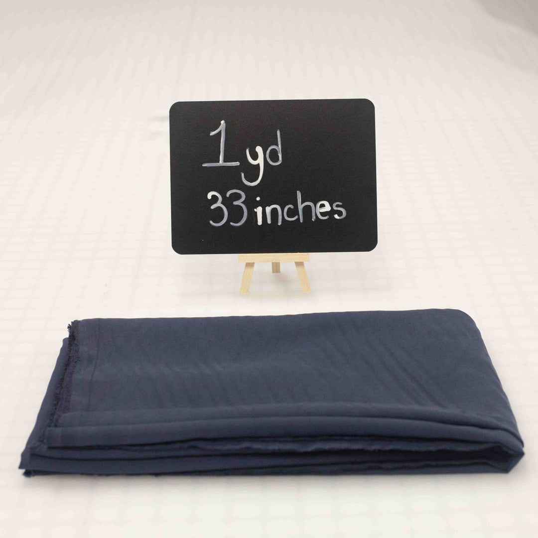 Close-up of navy Cupro fabric remnant showing soft, silk-like texture and elegant drape for sustainable fashion garments.