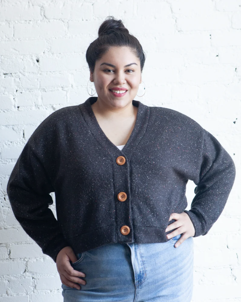 True Bias Marlo Sweater in cozy medium-weight knit with deep V-neck and large buttons, shown in mid-thigh length with patch pockets.