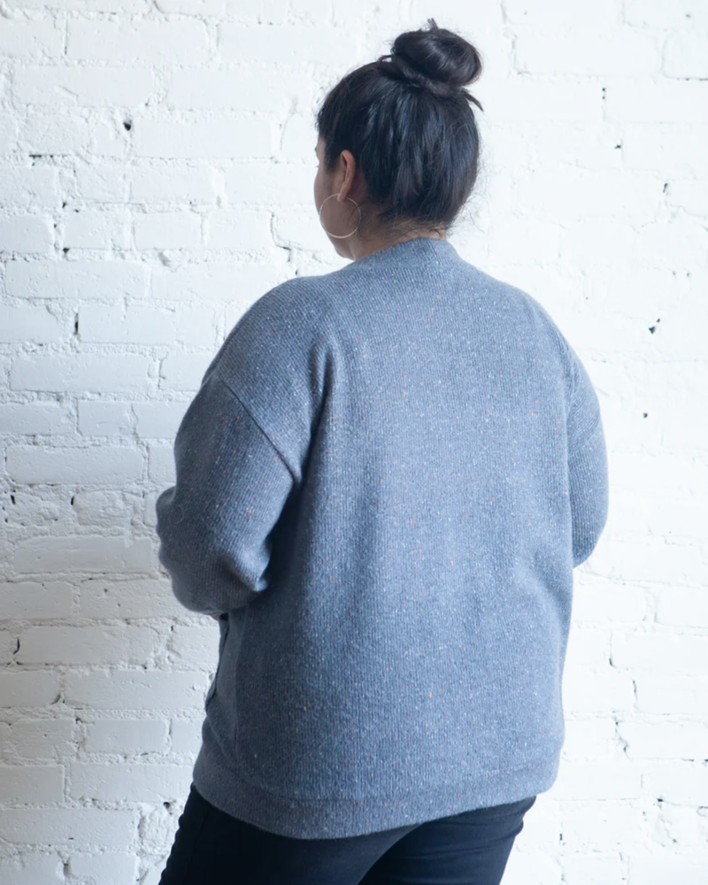 True Bias Marlo Sweater in cozy medium-weight knit with deep V-neck and large buttons, shown in mid-thigh length with patch pockets.