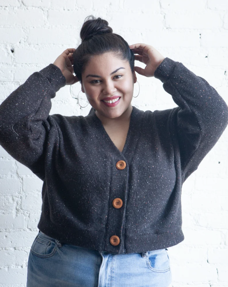 True Bias Marlo Sweater in cozy medium-weight knit with deep V-neck and large buttons, shown in mid-thigh length with patch pockets.