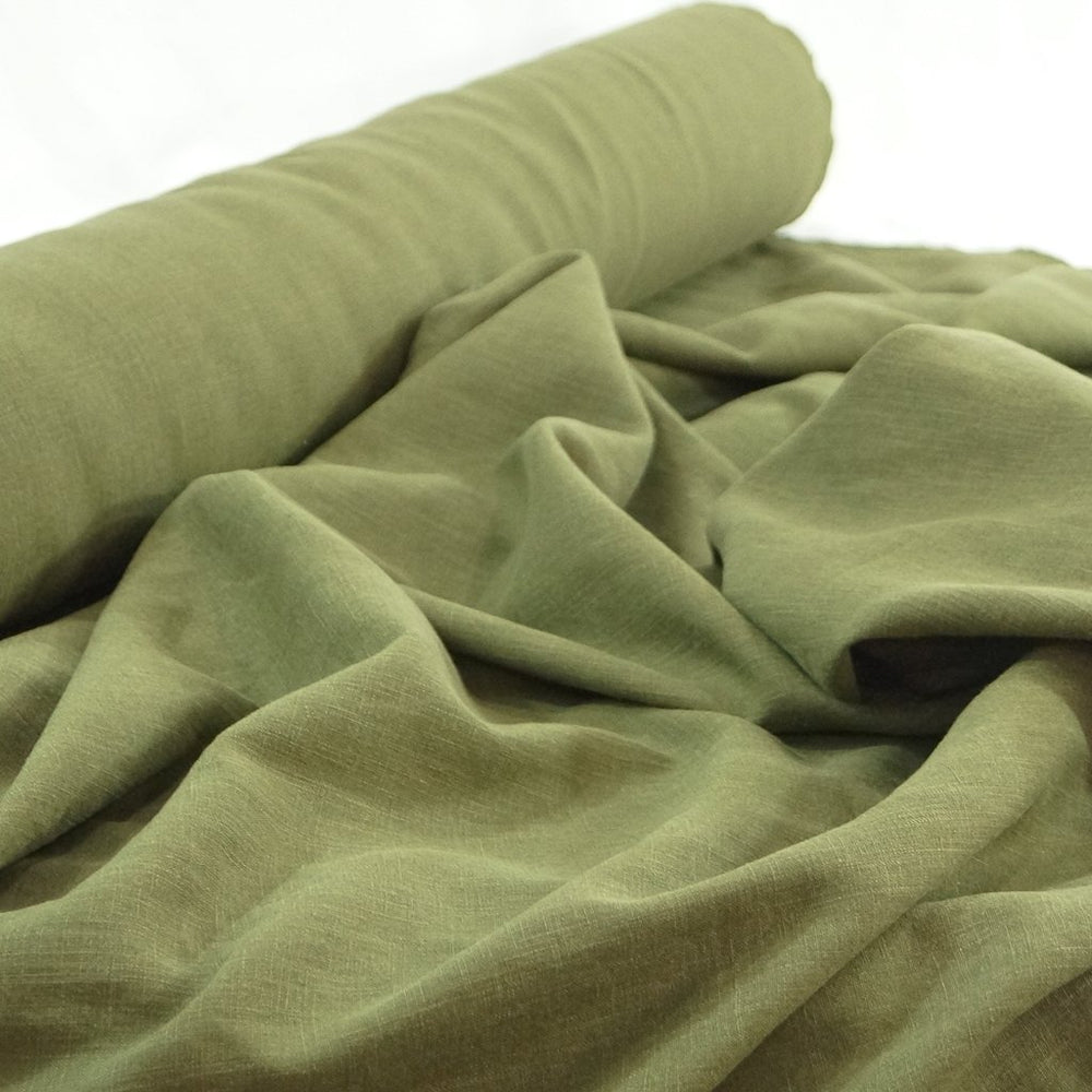 Soft Wash Linen fabric in rich olive green color, 100% pre-washed linen ideal for sewing dresses, jackets, pants, and more.


