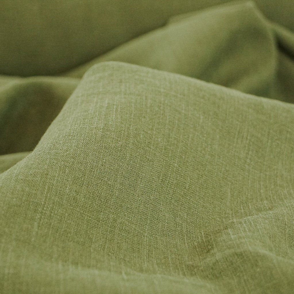 Soft Wash Linen fabric in rich olive green color, 100% pre-washed linen ideal for sewing dresses, jackets, pants, and more.


