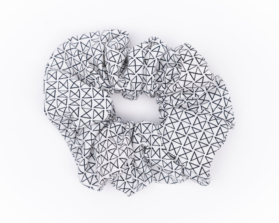 A collection of colorful, soft fabric scrunchies in various patterns and designs, perfect for matching with accessories like robes and makeup bags.