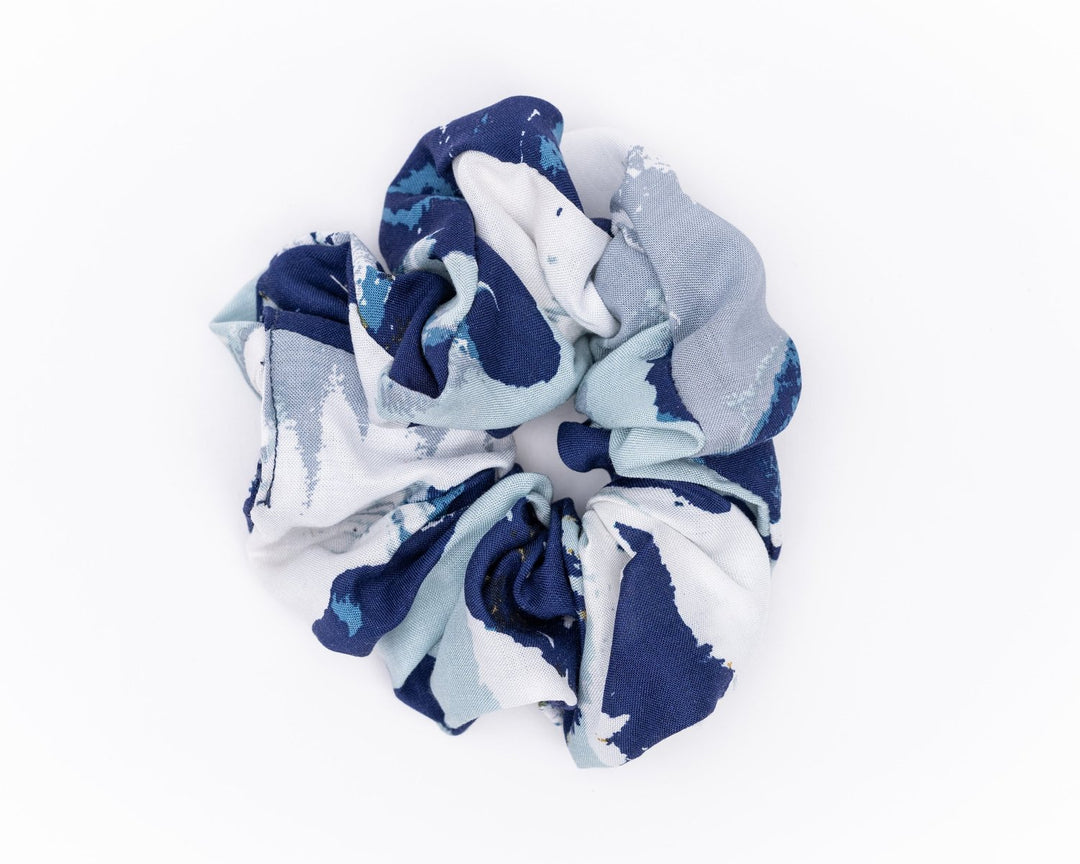 A collection of colorful, soft fabric scrunchies in various patterns and designs, perfect for matching with accessories like robes and makeup bags.