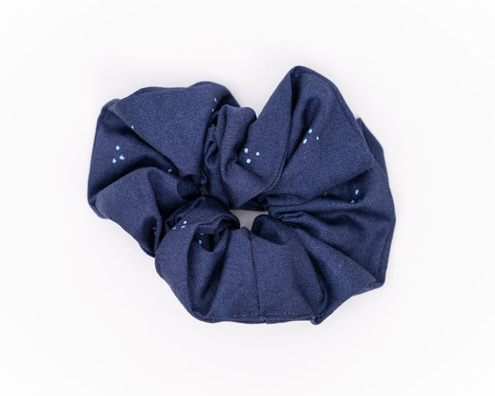 A collection of colorful, soft fabric scrunchies in various patterns and designs, perfect for matching with accessories like robes and makeup bags.