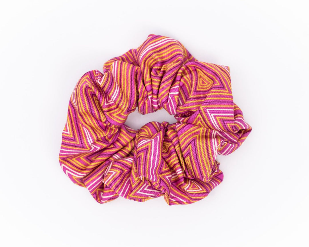 A collection of colorful, soft fabric scrunchies in various patterns and designs, perfect for matching with accessories like robes and makeup bags.