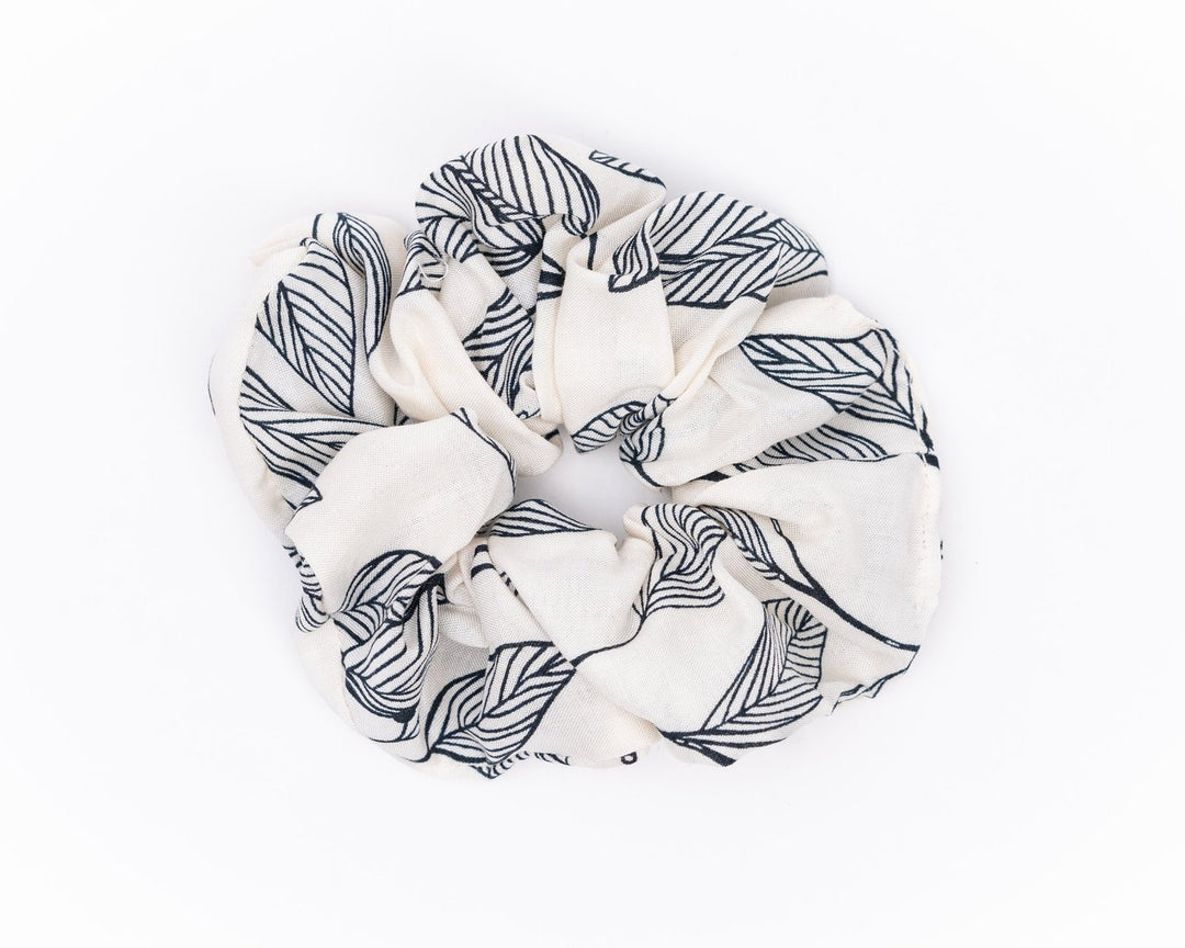 A collection of colorful, soft fabric scrunchies in various patterns and designs, perfect for matching with accessories like robes and makeup bags.