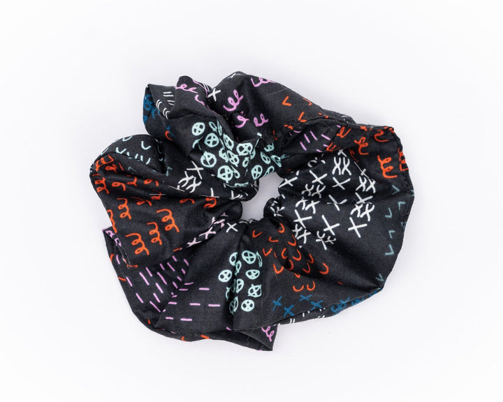 A collection of colorful, soft fabric scrunchies in various patterns and designs, perfect for matching with accessories like robes and makeup bags.