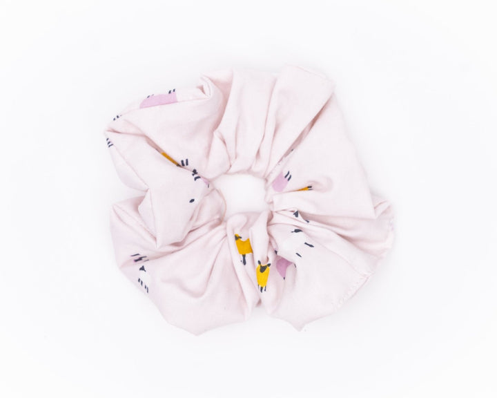 A collection of colorful, soft fabric scrunchies in various patterns and designs, perfect for matching with accessories like robes and makeup bags.