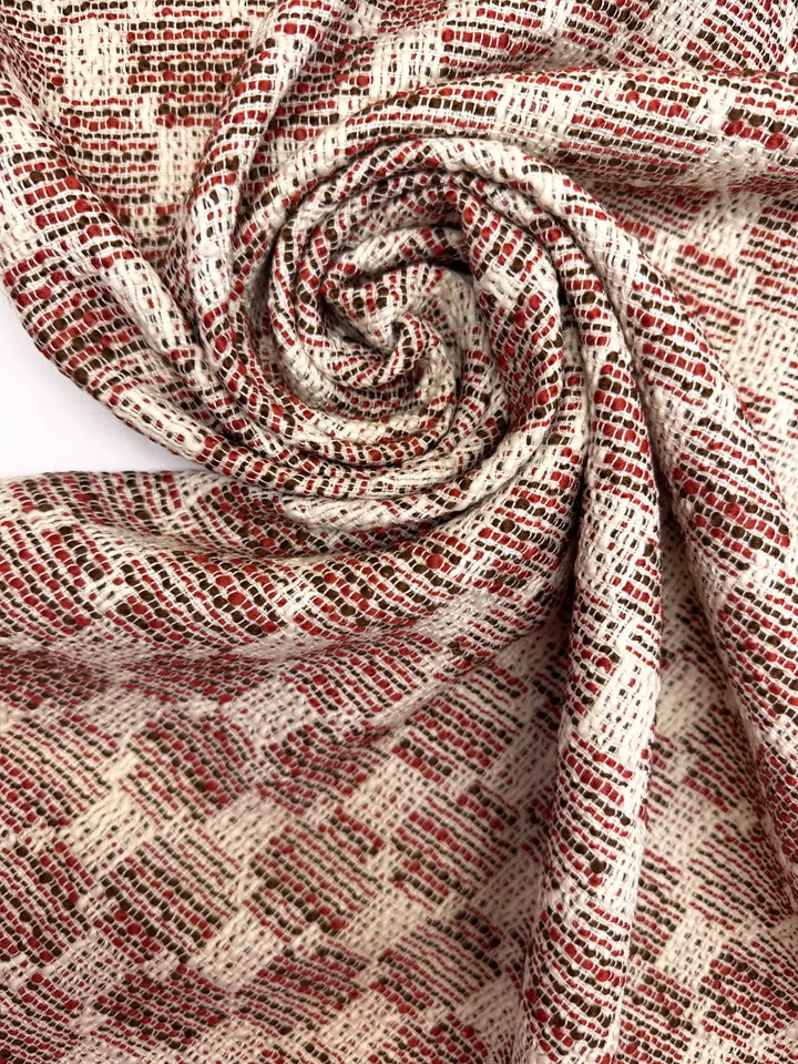 Premium Wool Boucle fabric in cream, red, and black cross-texture. Made from 85% Wool and 15% Cotton. Ideal for suiting, coats, and structured dresses.