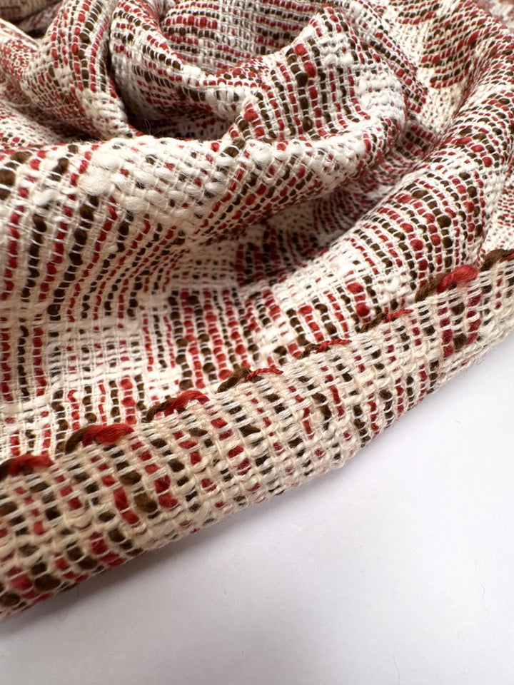 Premium Wool Boucle fabric in cream, red, and black cross-texture. Made from 85% Wool and 15% Cotton. Ideal for suiting, coats, and structured dresses.