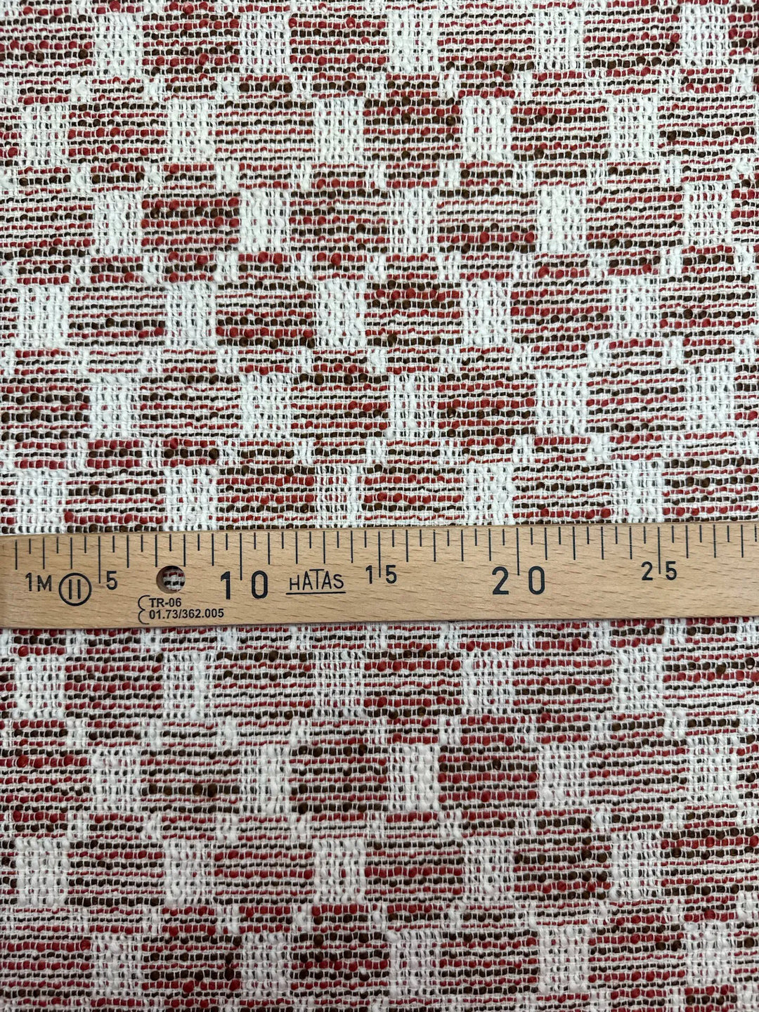 Premium Wool Boucle fabric in cream, red, and black cross-texture. Made from 85% Wool and 15% Cotton. Ideal for suiting, coats, and structured dresses.